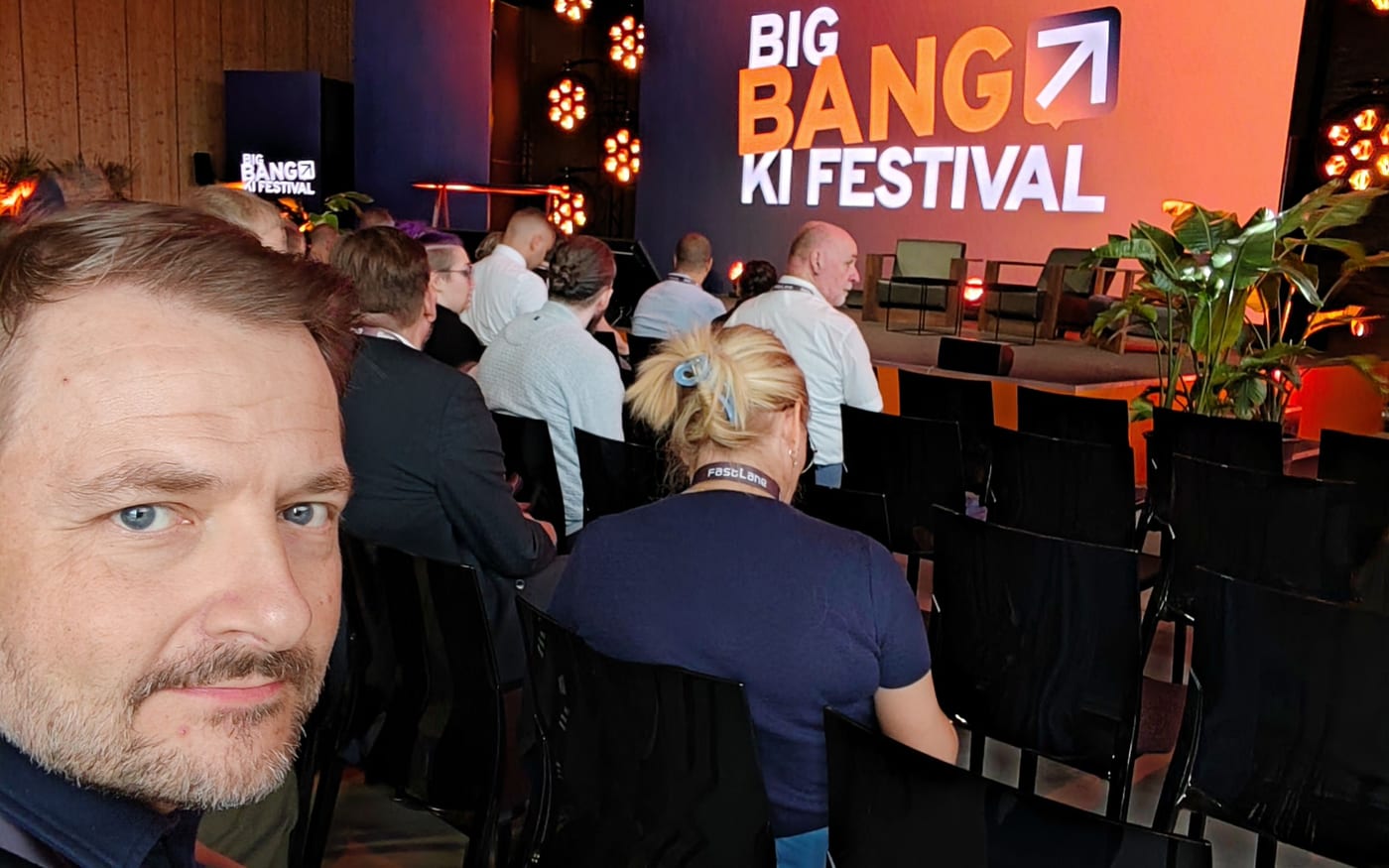 Martin Reichl im Publikum des Big Bang KI Festivals, im Hintergrund die Bühne